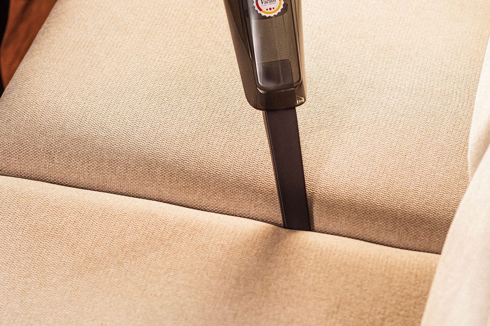 Suceur passé sur une assise de canapé beige, en gros plan, photo d’ambiance