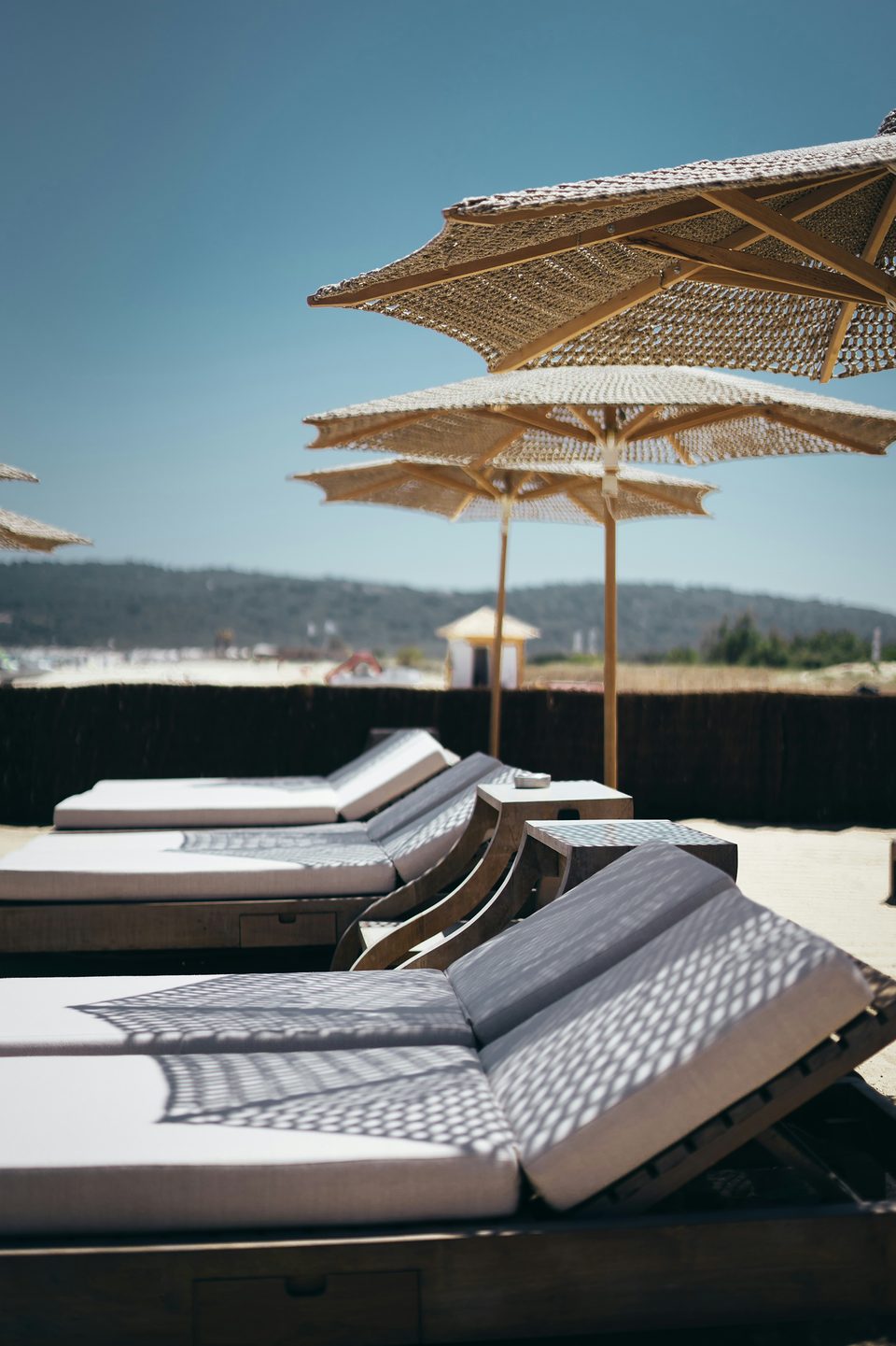 Bains de soleil sous des parasols de paille, ombre tressée sur la toile