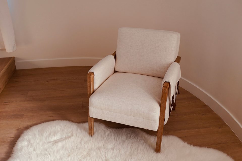 Fauteuil tapissé sur un parquet clair